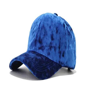 Close up detail of royal blue velvet baseball cap with curved brim, soft plush texture.
