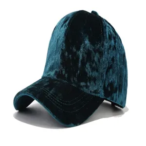Detail shot of the dark teal velvet texture, soft fabric surface, and curved brim design.
