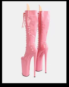 Detail view of pink patent leather knee high boots featuring extreme platform and stiletto heel.