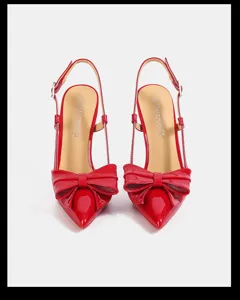 Detailed shot of red patent leather pointed toe slingback high heels with bow