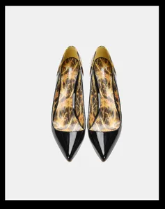 Elegants escarpins noirs en cuir verni a bout pointu, talon aiguille et semelle imprimee.