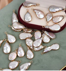 Primer plano de colgantes de perlas barrocas naturales con bordes dorados para hacer joyas.