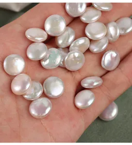 Closeup of natural freshwater baroque button pearls in hand, ideal for jewelry DIY.