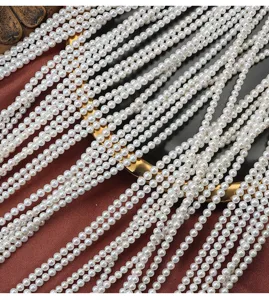 Primo piano di catene di perle d'acqua dolce naturali 3.5-4mm, fai da te semilavorate.