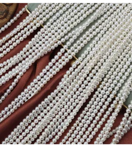 Dettaglio in primo piano di perle d'acqua dolce naturali 3.5-4mm per collane fai da te.