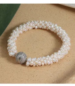 Detailaufnahme des gewebten Süßwasserperlenarmbands mit glitzerndem Magnetkugelverschluss.