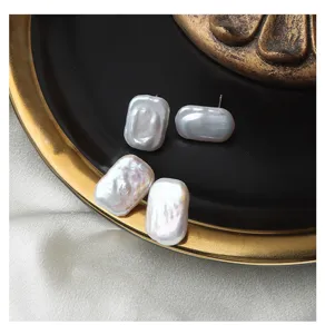 Detail shot of rectangular baroque pearl stud earrings with natural luster and sterling silver pins.