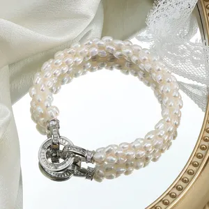 Elegant mehrsträngiges Süßwasser-Reisperlenarmband mit funkelndem Kristallverschluss.