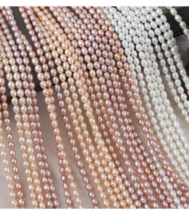 Primo piano di fili di perle di fiume naturali con consistenza liscia e tonalità colorate.