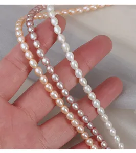 Primo piano dettagliato di fili di perle d'acqua dolce naturali bianche, rosa e pesca.