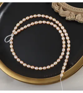 Dettaglio di perle d'acqua dolce naturali rosa, filo di perle semilavorate per il fai-da-te.