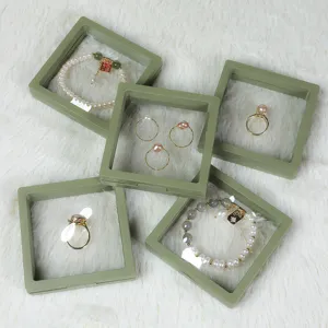 Detaillierte Ansicht grüner schwebender Schmuck-Vitrinen mit schönen Perlenarmbändern.