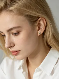 Detail view of S925 sterling silver T-bar stud earring with green zircon on model