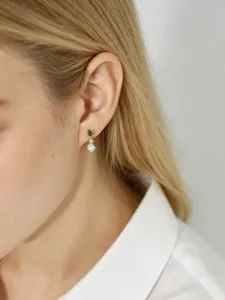 Close-up of S925 sterling silver stud earring with emerald green zircon and pearl