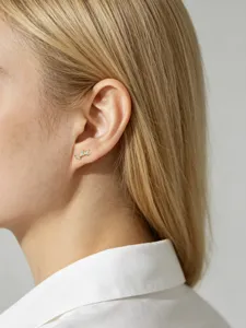 Close-up of elegant leaf-shaped gold stud earrings with sparkling marquise zircons.