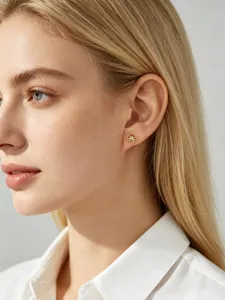 Close-up of a delicate S925 sterling silver gold bow stud earring set with a zircon stone