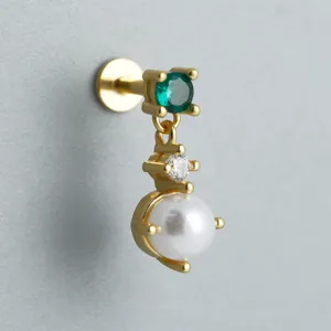 Macro view of gold S925 sterling silver labret stud with green gem and white pearl