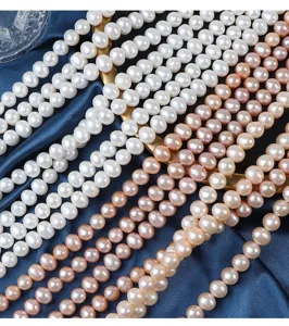Primo piano dettagliato di perle d'acqua dolce naturali 7mm, forma ovale liscia, fili.