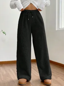 Detail van zwarte sherpa fleece wijde joggingbroek voor dames met gezellige pluche textuur.