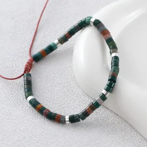 Natural stone cylinder bead bracelet with stainless steel spacers and adjustable red cord.