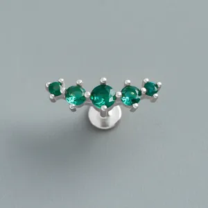 Macro view of curved S925 sterling silver labret earring set with five green zircons