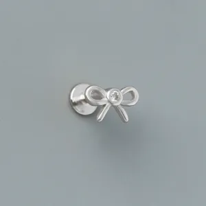 Close-up view of a minimalist S925 sterling silver bow stud earring with CZ stone.