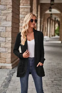 Detailed view of women's black ribbed knit long sleeve cardigan in outdoor street scene.