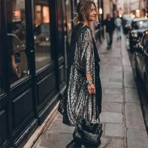 Detailed view of the sparkling sequin cardigan draped on a model in a street setting.