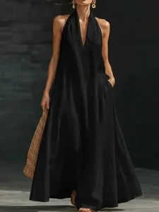Primo piano dell'elegante abito lungo nero con scollo all'americana, scollo a V e tasche.