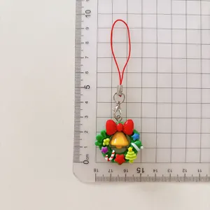 Detailansicht des Weihnachtskranz-Anhängers mit bunten Harz-Charms und rotem Umhängeband.