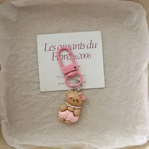 Cute cartoon pajama bear keychain pendant featuring pink clasp and cute bow charm detail.