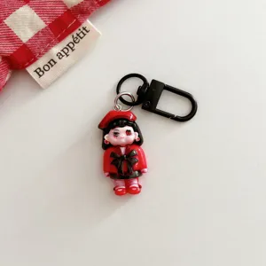 Close up detail of the dark gothic cartoon girl keychain pendant with red and black design.