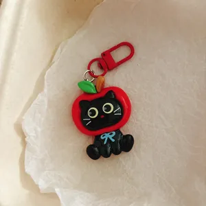 Close-up of cute black cat apple keychain pendant detail, creative bag accessory hanging ornament