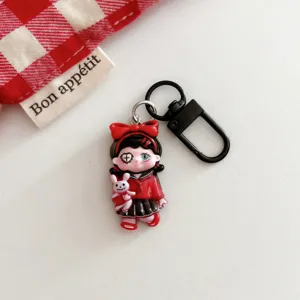 Close-up detail of the gothic cartoon girl keychain pendant with black metal hardware clasp.