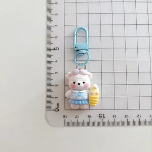 Cute surfing bear keychain detail showing the flocked cartoon pendant and blue clasp.