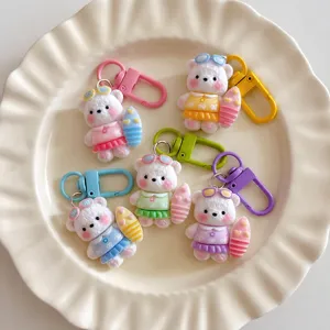 Cute cartoon surfing bear keychain, colorful resin bag charm and student backpack pendant.
