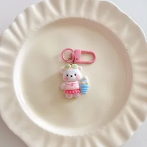 Cute surfing bear keychain charm detail view, pink resin bag pendant and schoolbag accessory.