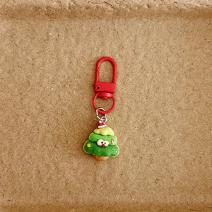 Gros plan détaillé du charm de sac mignon en forme d'arbre de Noël, accessorio festif.