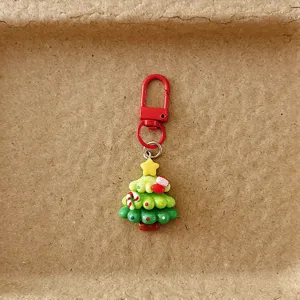 Nahaufnahme des niedlichen Weihnachtsbaum Taschenanhängers mit rotem Karabiner und Dekor.