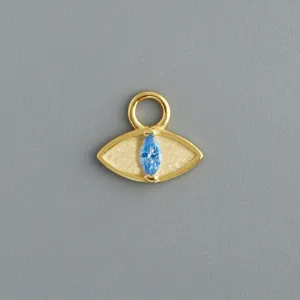 Dettaglio del ciondolo malocchio, argento placcato oro, zircone blu, accessorio per gioielli.