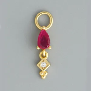 Dettaglio del ciondolo per orecchino in argento dorato con rubino rosso e brillante diamante.