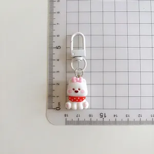 Cute cartoon puppy keychain with pink bow and red polka dot scarf, lovely bag accessory.
