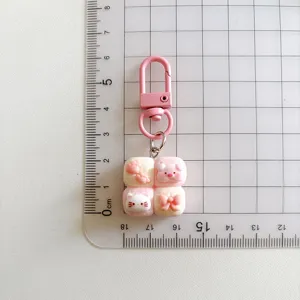 Cute cartoon bread keychain detail view with cute cat and pink bow design, metal clasp.