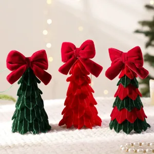 Fluwelen kerstboom tafeldecoratie met grote rode strik voor sfeervolle feestelijke inrichting.
