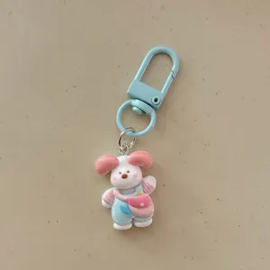 Cute cartoon puppy keychain detail shot, pink and white dog pendant with blue clasp.