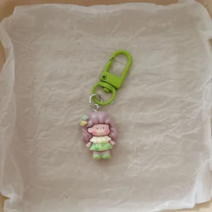 Cute cartoon girl keychain with green clasp, sweet bag charm and student backpack pendant.