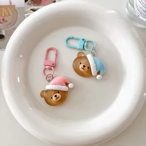 Close-up detail of cute cartoon sleeping bear keychains with colorful hats in a ceramic bowl.