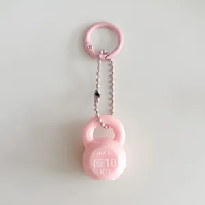 Dettaglio portachiavi mini kettlebell rosa, ciondolo borsa carino accessorio zaino fitness.