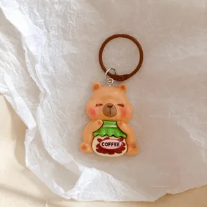 Cute coffee capybara keychain detail, resin animal charm, backpack bag accessory.