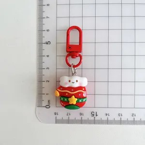 Close-up detail of the cute Christmas cartoon character keychain with metal hook and pendant.